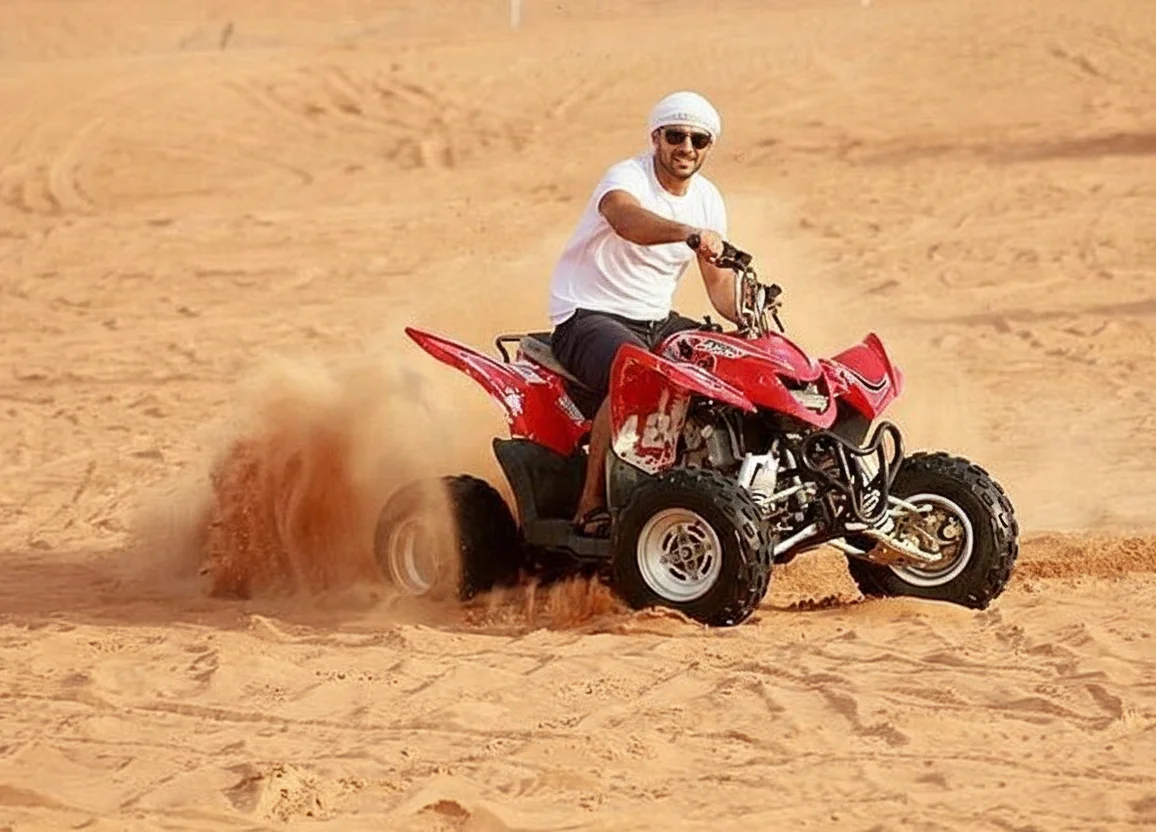 Quad bike rider climbing red sand dunes in Lahbab Desert near Dubai
