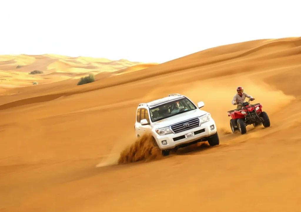 Quad bikes parked on sand dunes during sunset