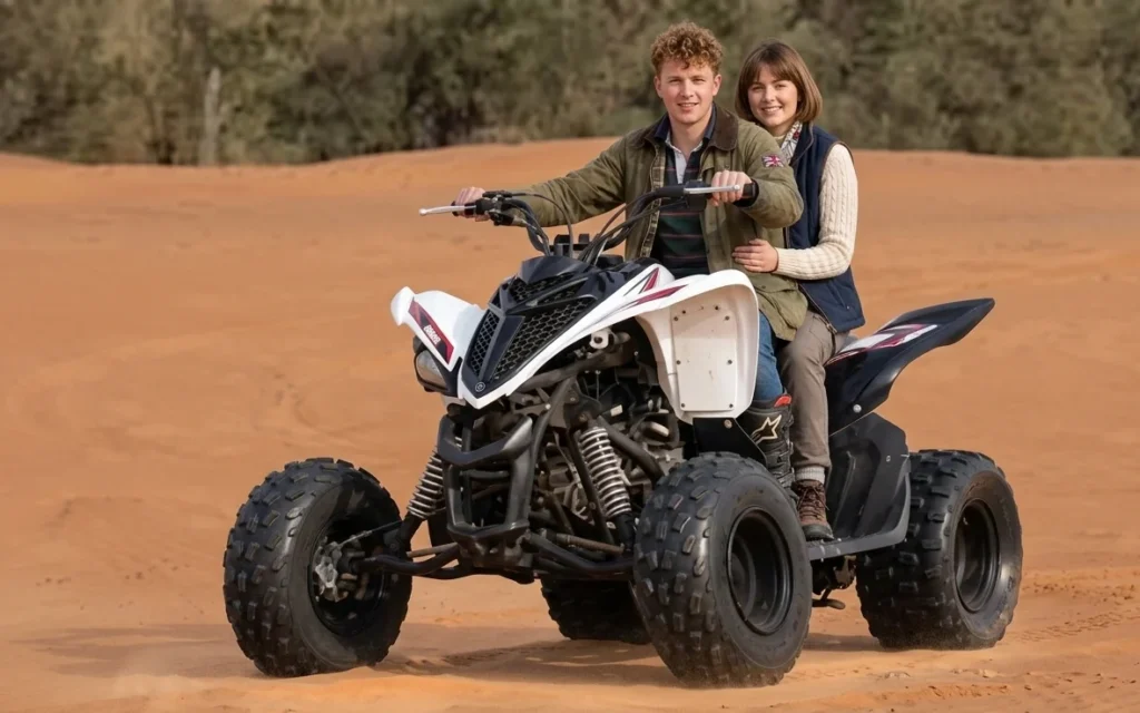 Adventure tourist riding powerful quad bike across Dubai desert dunes during sunset desert tour showing popular quad biking activity for visitors