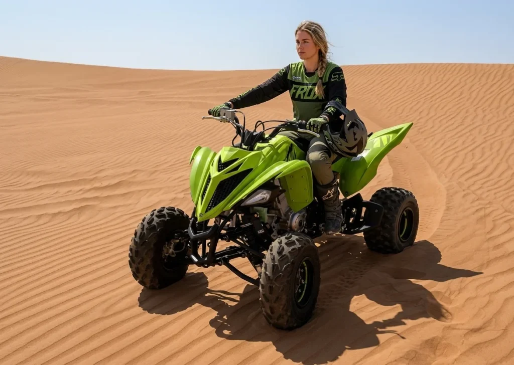 Tourist riding a quad bike across red sand dunes in Dubai desert during a guided quad biking adventure experience, learning safe riding technique.