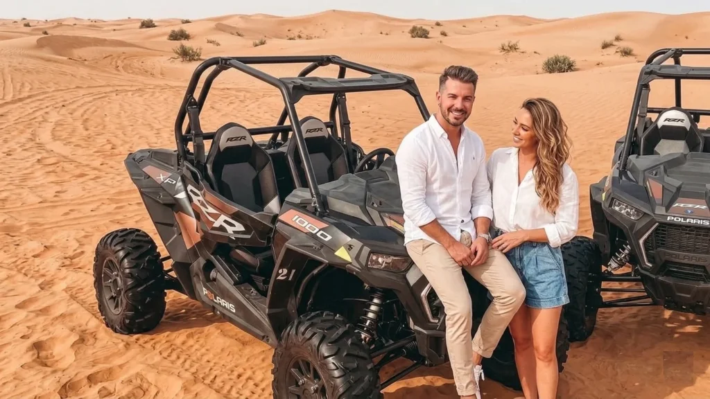 Instructor explaining dune buggy controls to beginner in Dubai desert before ride, ensuring proper understanding of driving techniques and safety rules