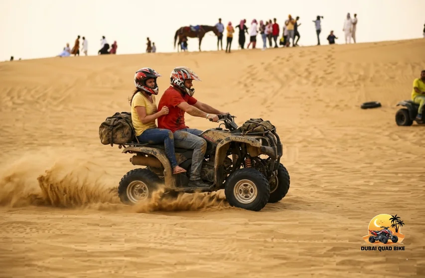 Tourist enjoying ATV ride in Dubai desert surrounded by red dunes, open sky and soft sand tracks creating a fun and controlled off road experience