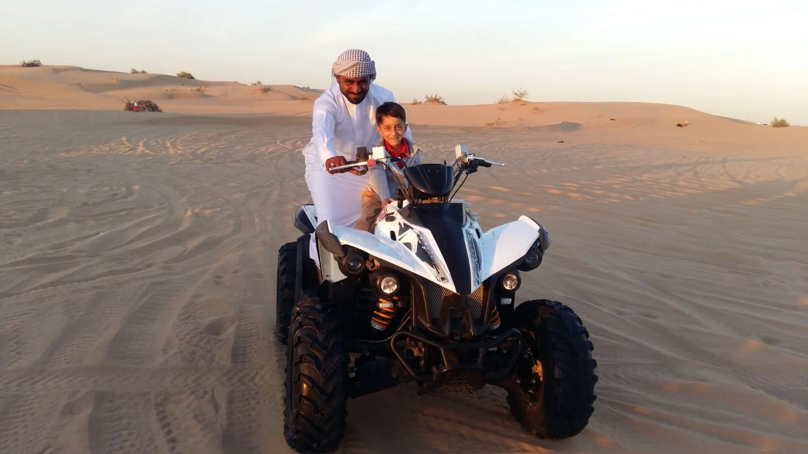 Quad biking Dubai desert sunset ride across golden dunes with scenic view